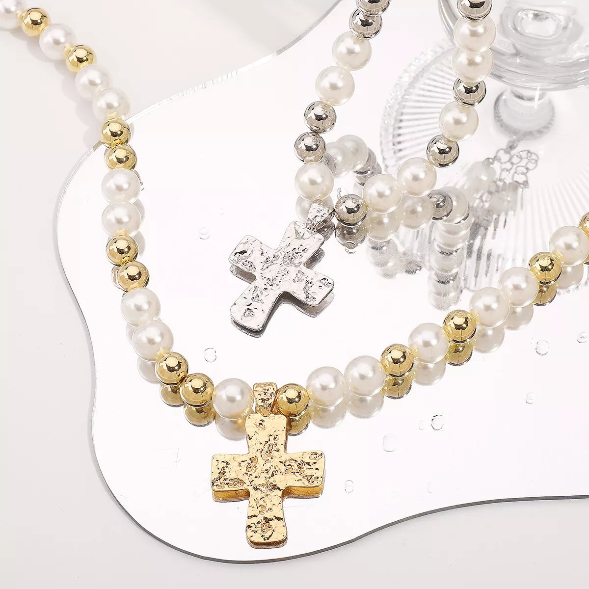 Pearl and cross pendant necklace featuring a silver chain and elegant design, perfect for stylish accessorizing.