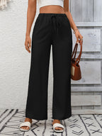 Women's high-waisted wide-leg drawstring pants in soft breathable viscose, shown in a relaxed fit with a drawstring waist.