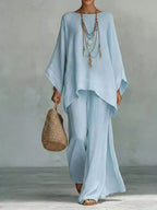 Plus size full size round neck top and wide-leg pant set by Trendsi, featuring a comfortable, stylish matching outfit.