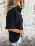 Women's collared half sleeve button-down blouse by Trendsi, featuring a sophisticated office shirt style with a classic collar.