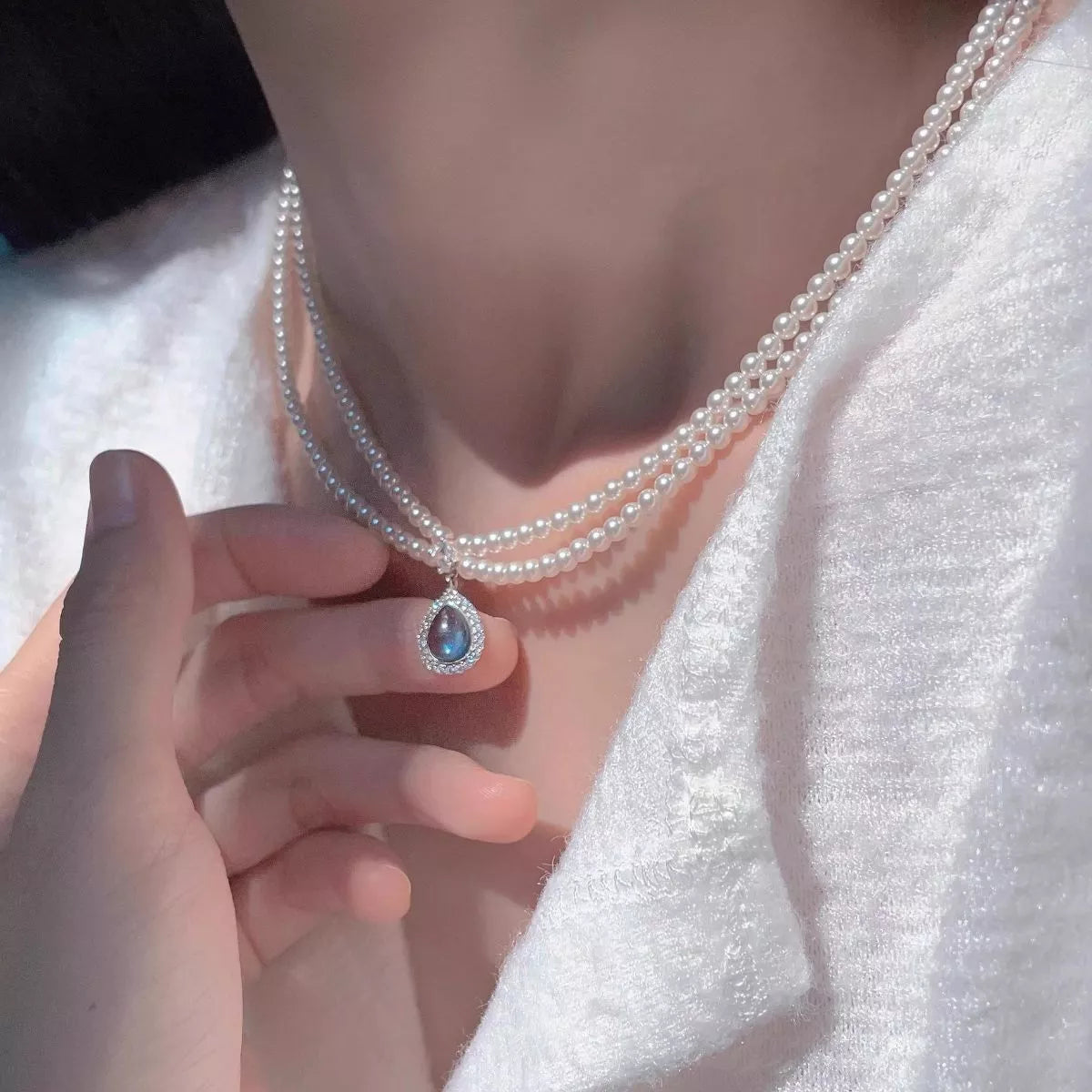 Double layered pearl necklace with teardrop pendant, featuring elegant white pearls and a silver chain, by Shopimist.