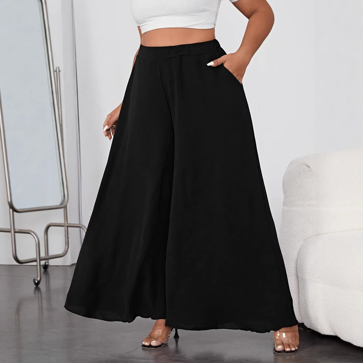 Solid black wide-leg trousers featuring a high waist and side pockets.