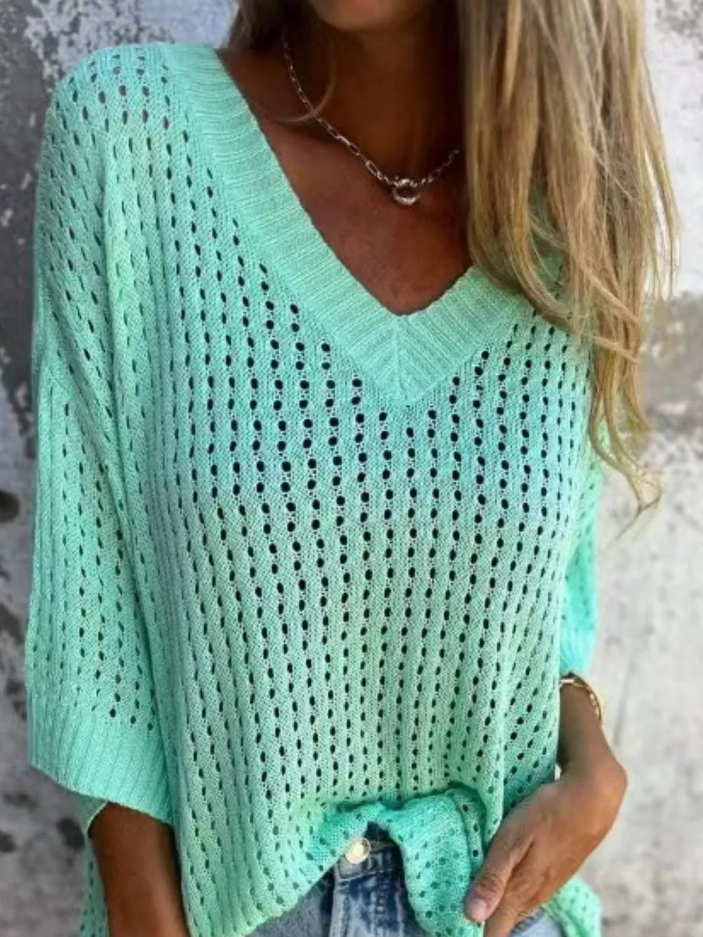 Mint green open-knit V-neck sweater with loose fit and textured pattern.