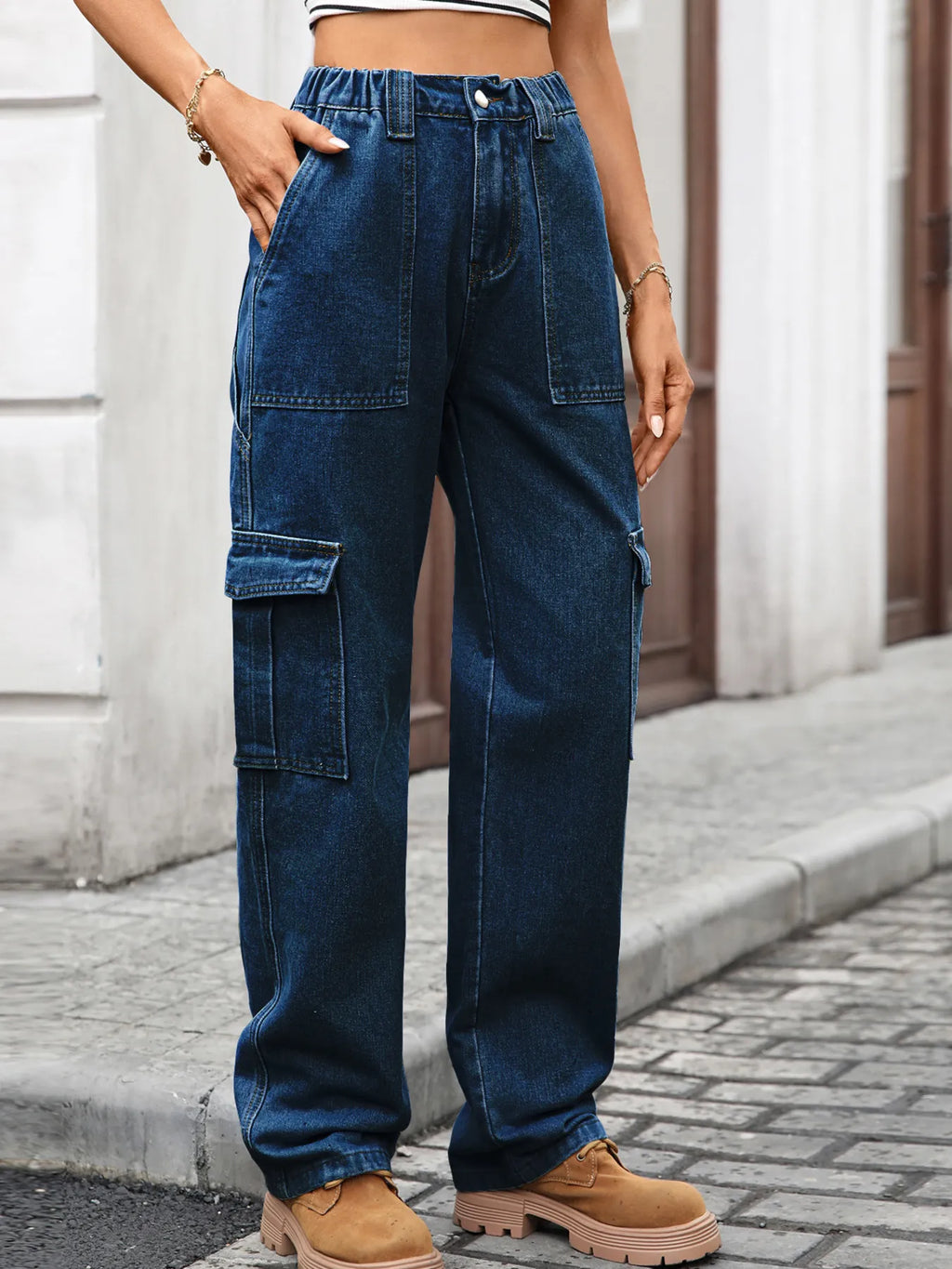 High-waisted cargo denim jeans from Plush Fashion Shop with multiple pockets and a relaxed fit, displayed on a white background.