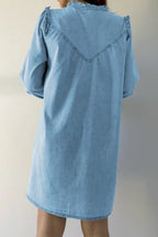 VYSN denim dress with button-up front, notched long sleeves, and a fitted silhouette, displayed on a hanger.