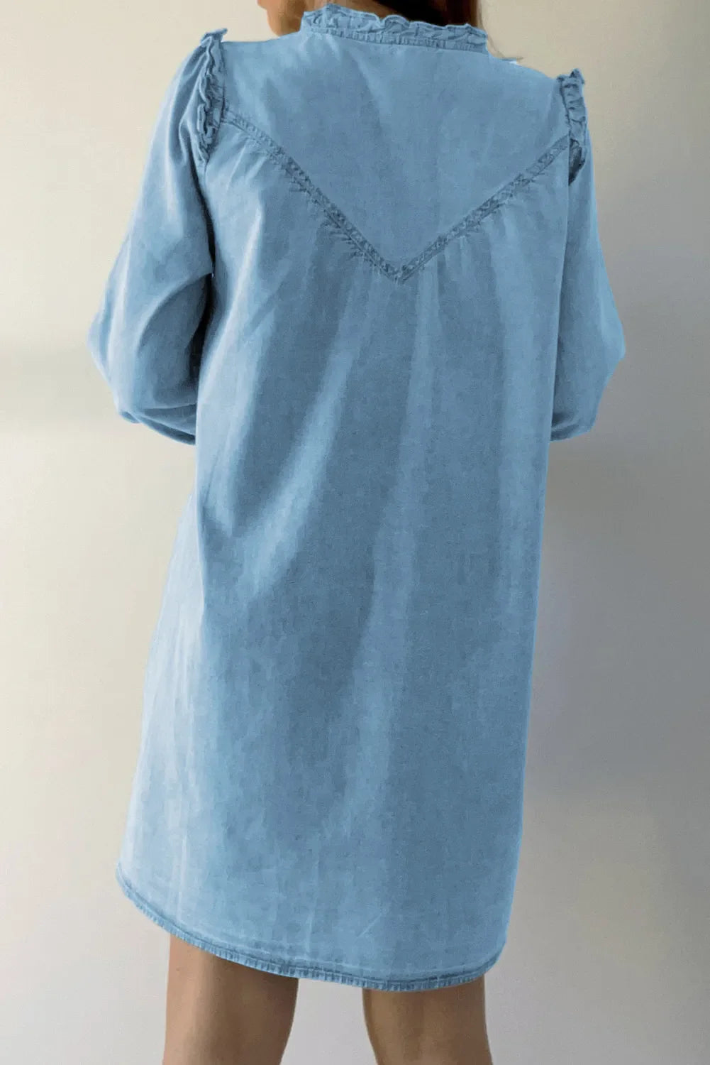 VYSN denim dress with button-up front, notched long sleeves, and a fitted silhouette, displayed on a hanger.