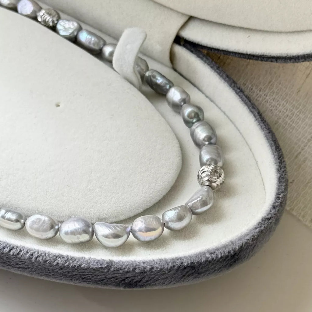 Pearl choker necklace by Shopimist featuring a string of elegant white pearls on a delicate black cord.