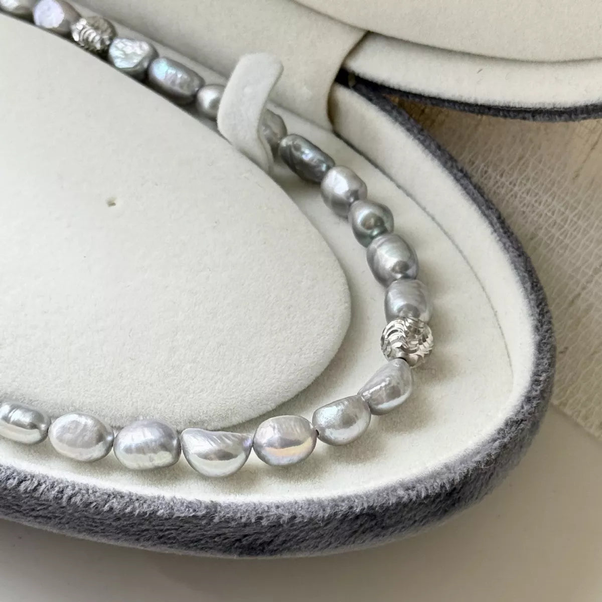 Pearl choker necklace by Shopimist featuring a string of elegant white pearls on a delicate black cord.