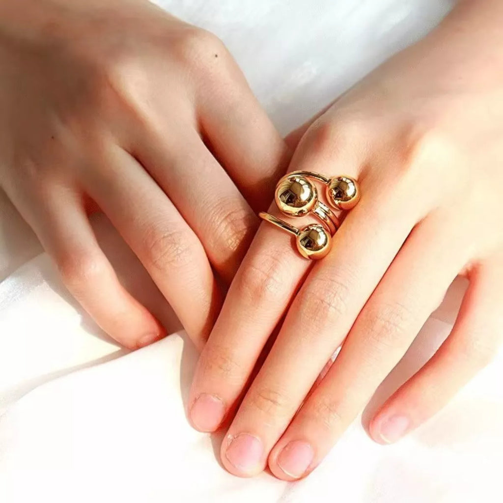 Multi-layered ball ring from Shopimist featuring stacked silver bands and spherical accents, showcasing its modern layered design.