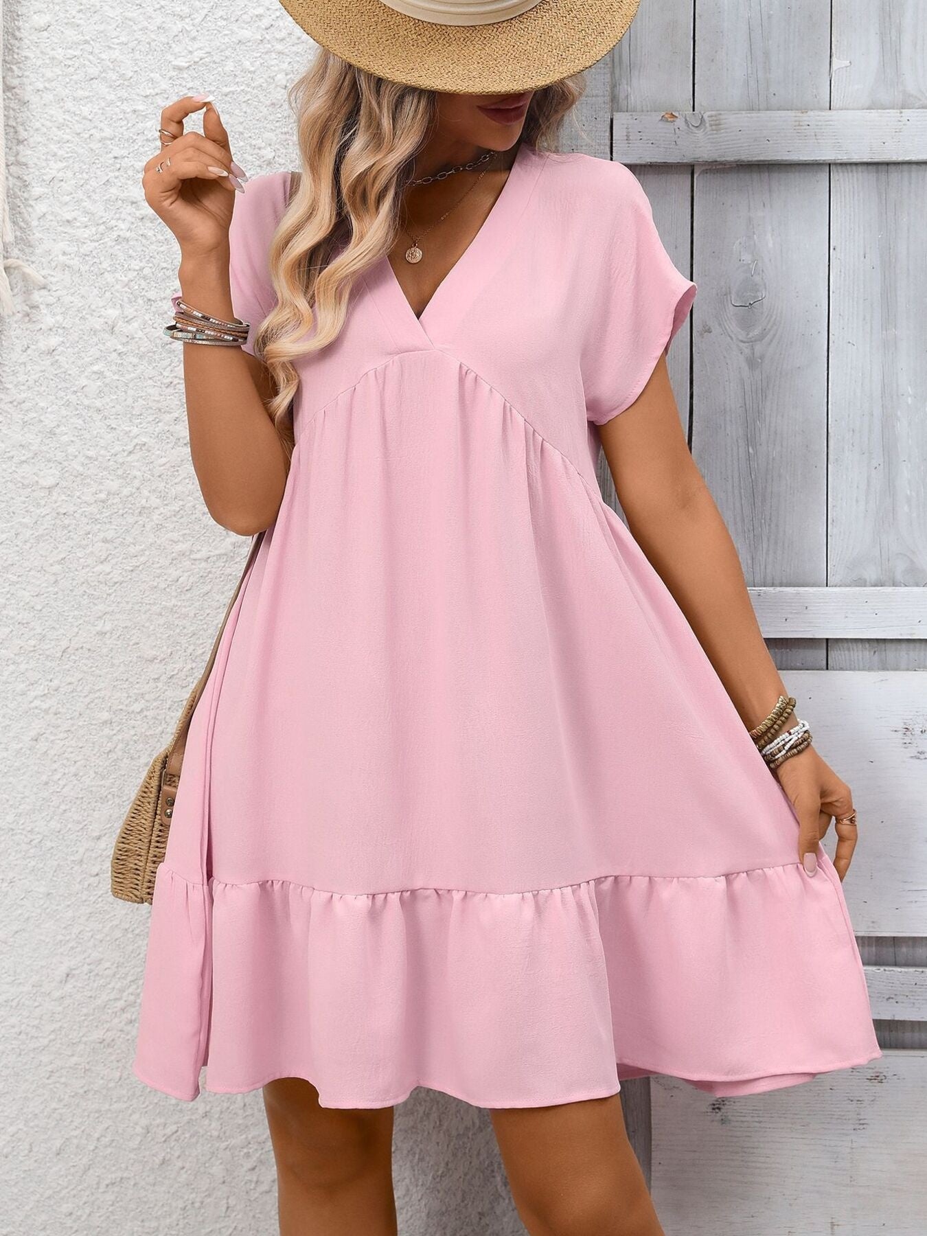 Women's casual V-neck mini dress with ruffle hem and ruched detailing by Trendsi, featuring a stylish and comfortable design.