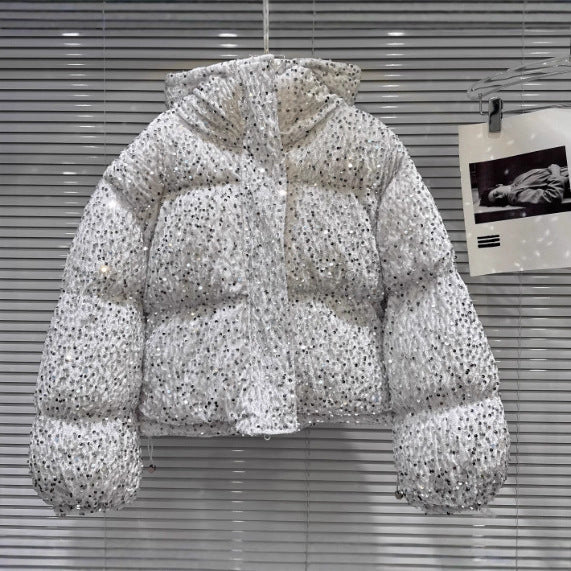 White hooded puffer jacket covered in shimmering sequins, styled with horizontal baffles and a front zipper.