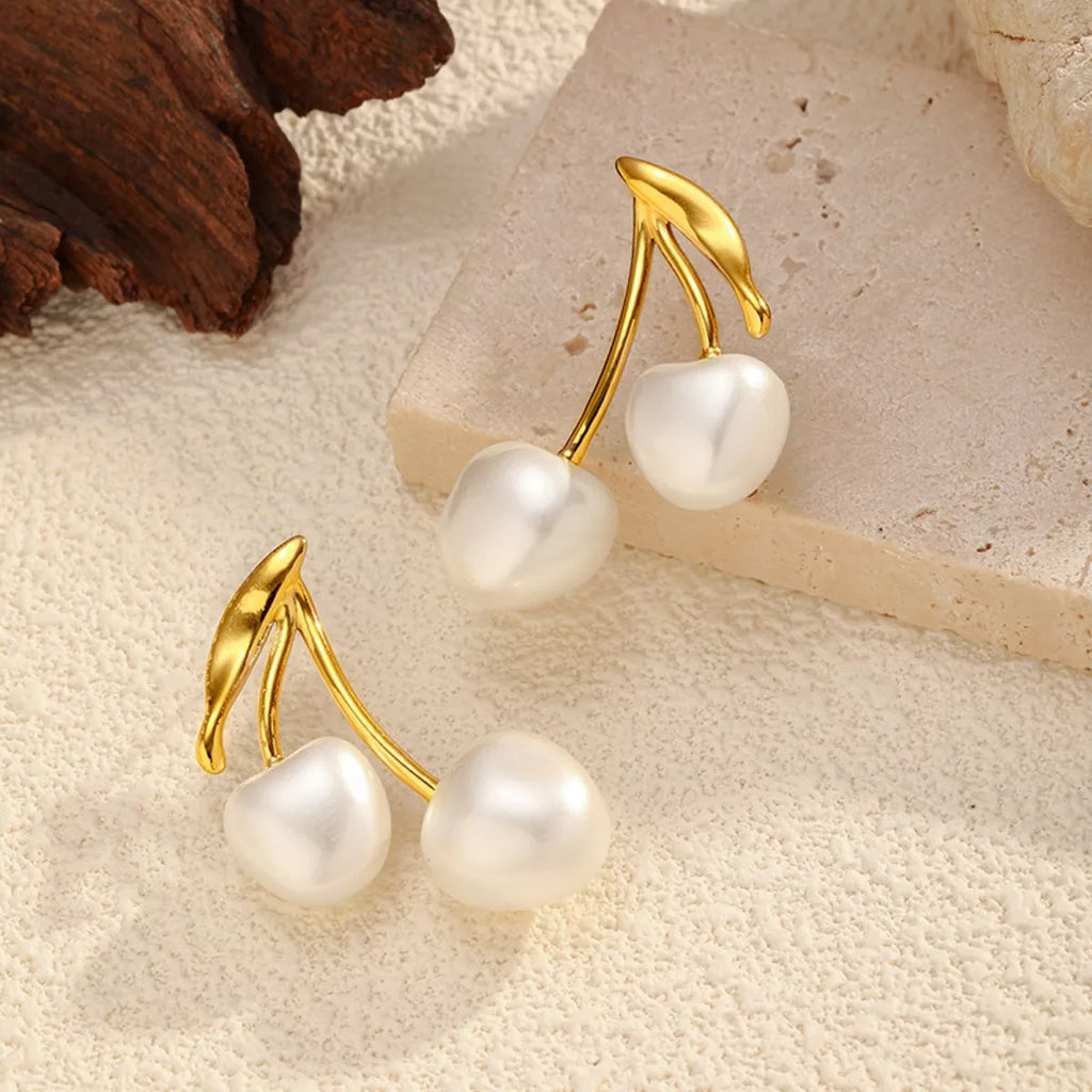 Pearl cherry drop earrings by Shopimist featuring dangling pearl and cherry-shaped charms on silver hooks.