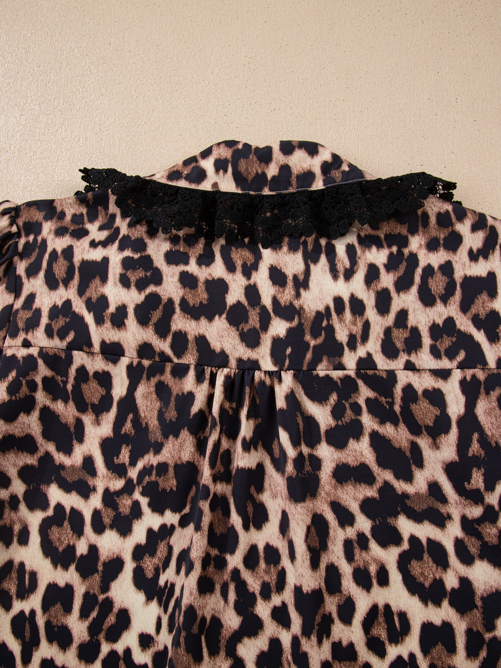 Leopard print short sleeve blouse with lace trim and button front from Plush Fashion Hub, stylish women's top with bold pattern.