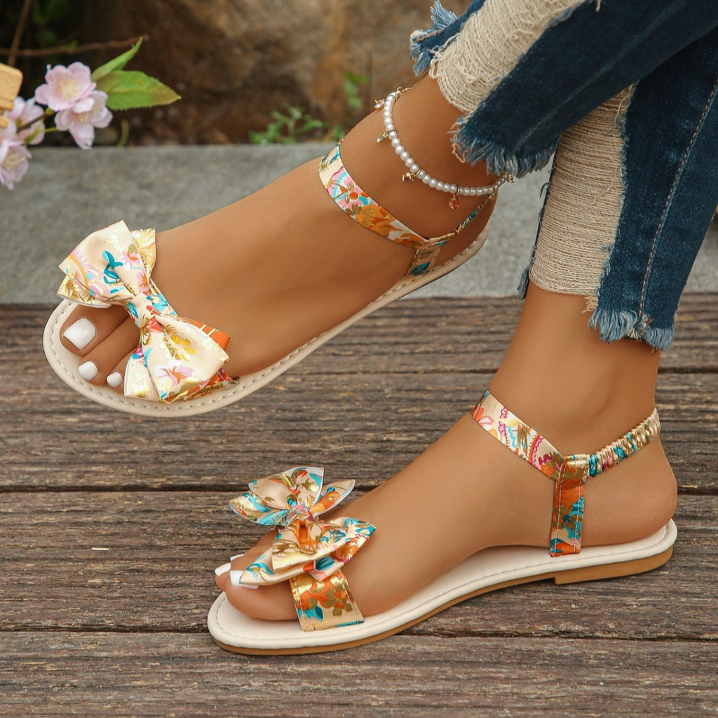 Floral bowknot ankle strap flat sandals by Trendsi, comfortable women's summer shoes featuring colorful floral accents and open-toe design.