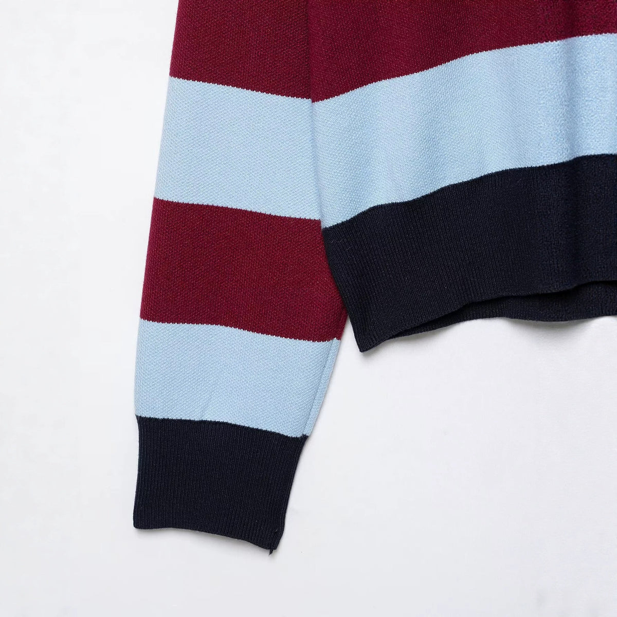 Maroon, light blue, and navy knit sweater with horizontal stripes, long sleeves, and ribbed cuffs and hem.