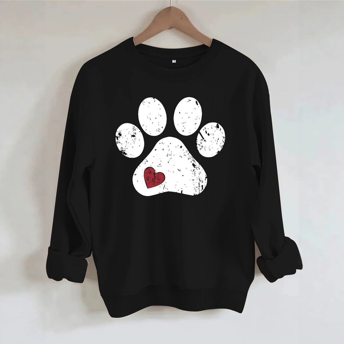 Black knit crewneck sweatshirt with a distressed white paw print graphic and small red heart detail.