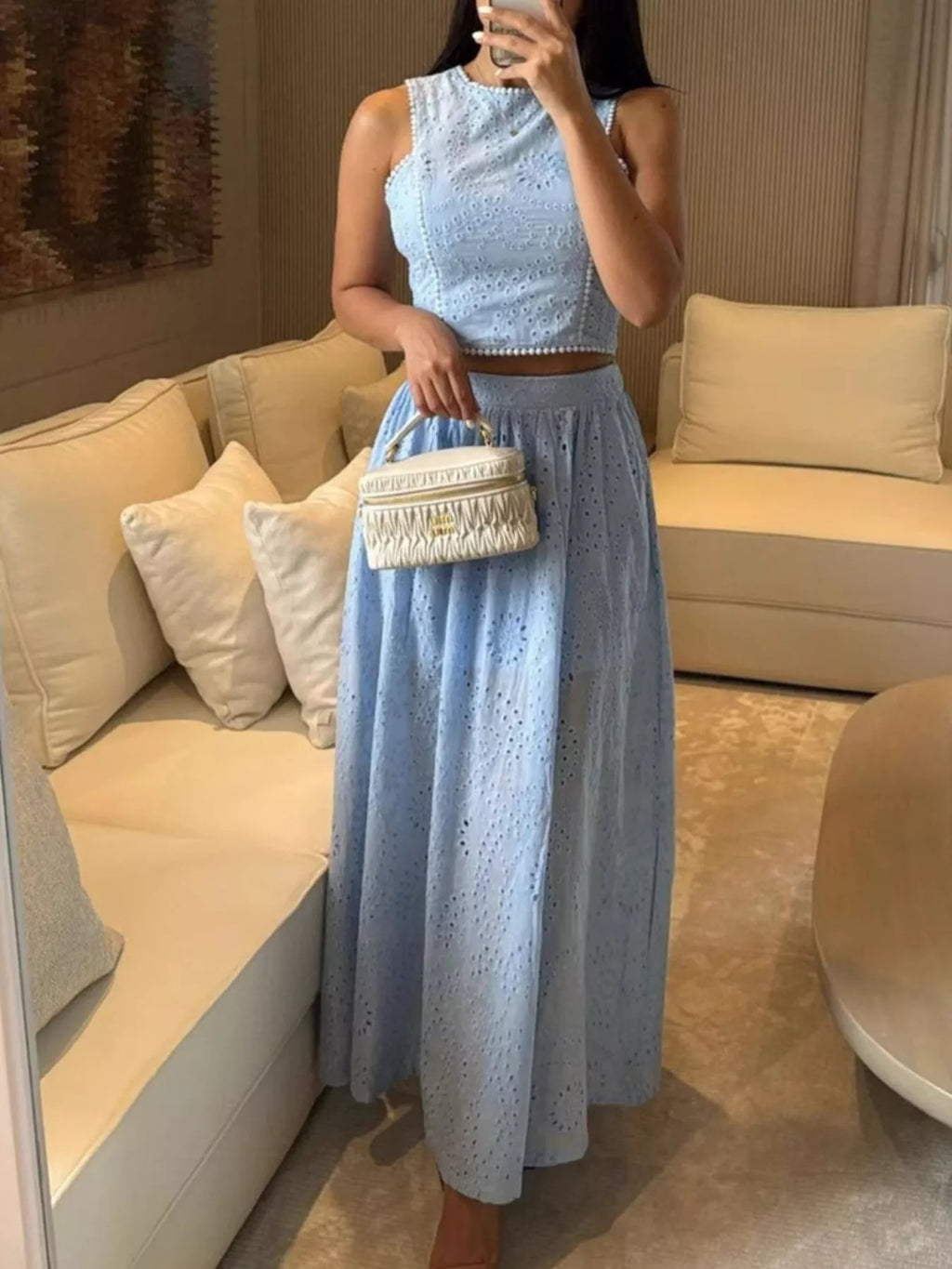 Trendsi eyelet crop top and maxi skirt set displayed on a model, featuring lightweight fabric and eyelet details for a stylish look.