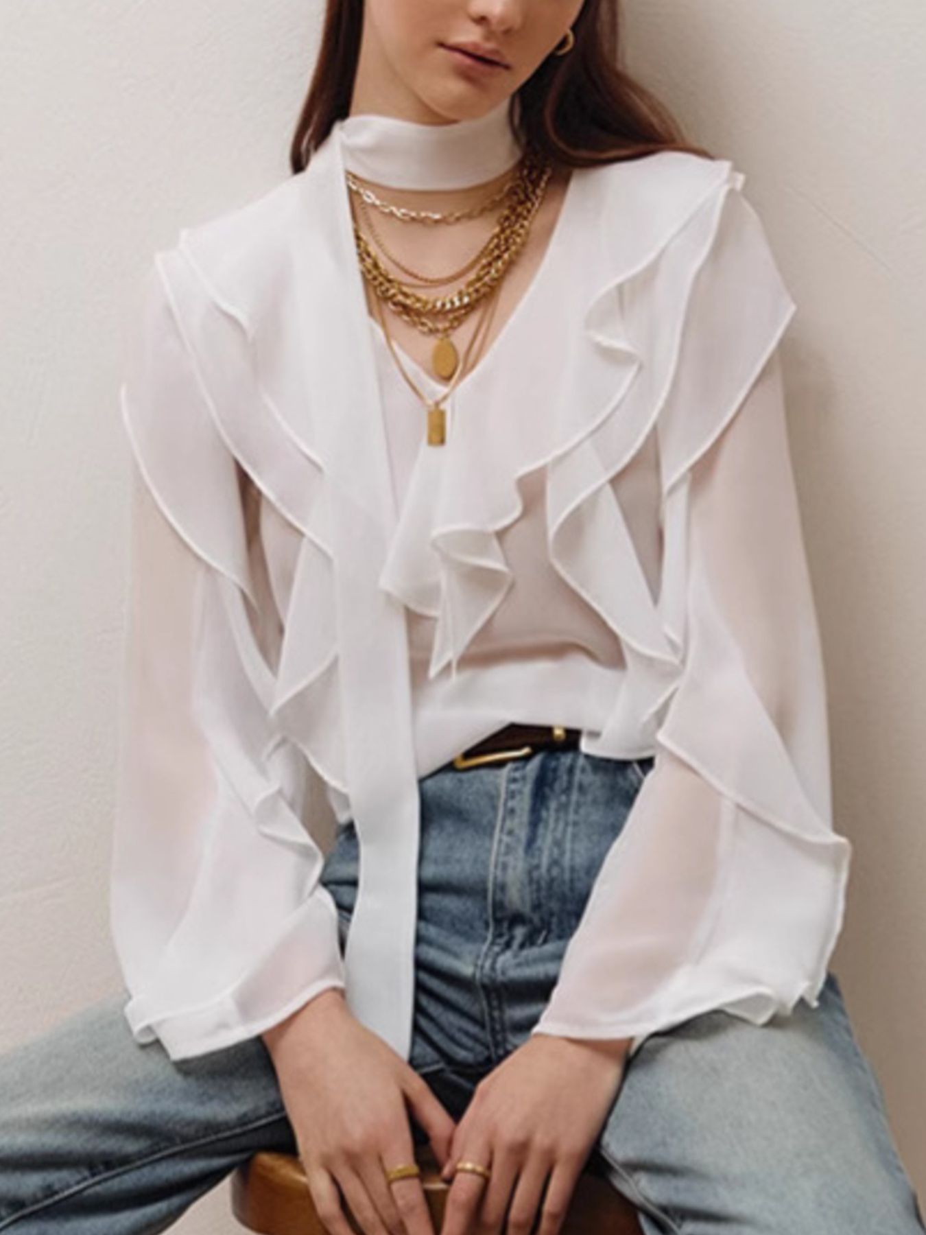 Elegant chiffon blouse with ruffle trim and tie neck detail, featuring a flowy fabric and feminine design.