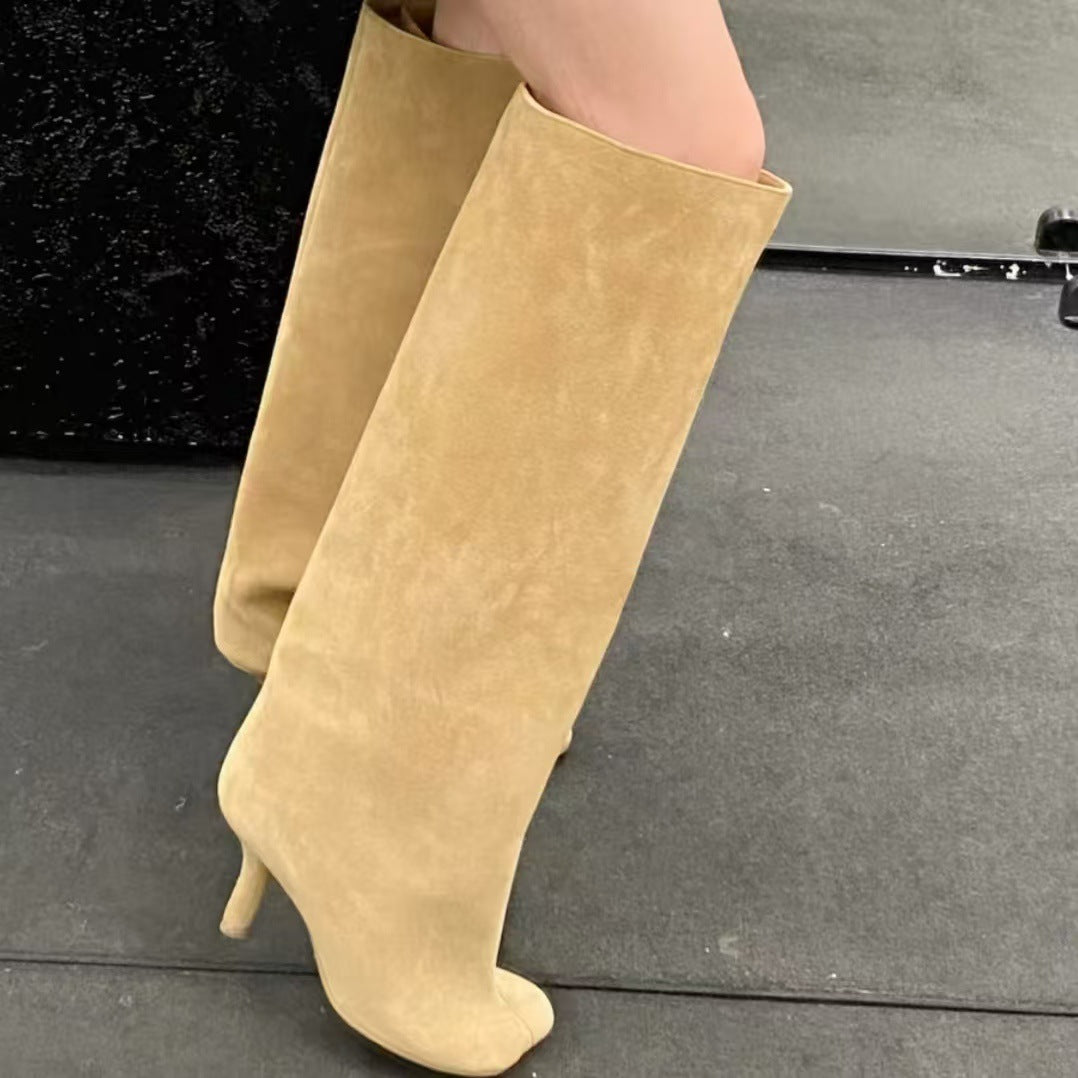 Tan suede knee-high boots with stiletto heels and split toes.