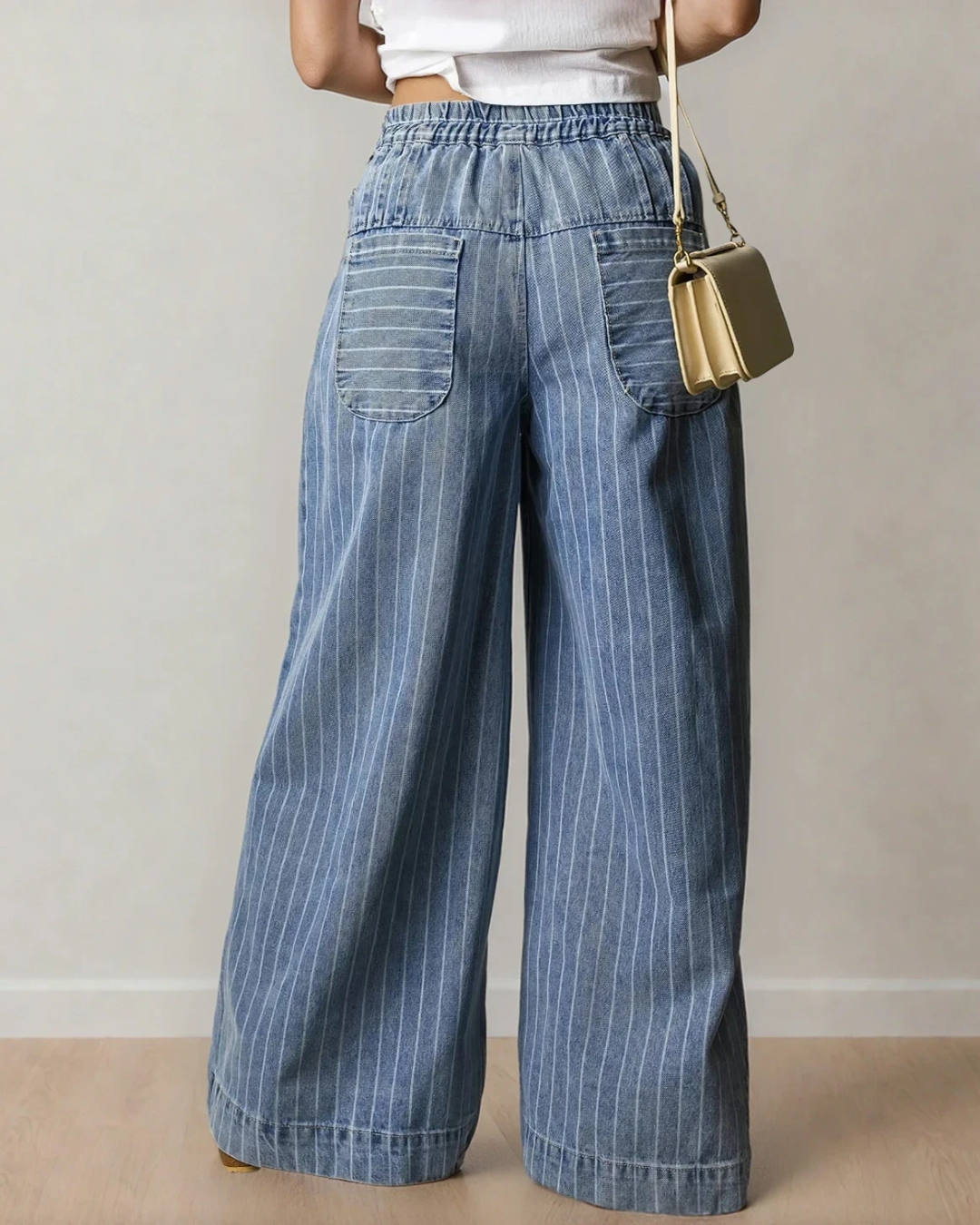 Rear view of blue striped wide-leg denim jeans with an elastic waist and back pockets.