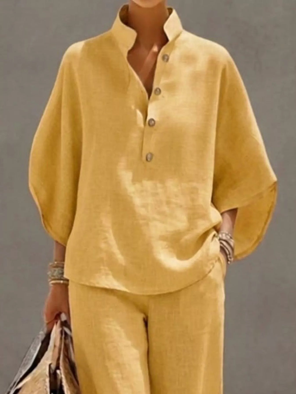 Plus size women's two-piece dress set with button details, 3/4 sleeves, and matching pants, by Trendsi, shown in a stylish outfit.