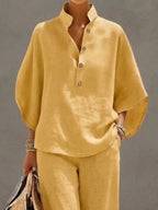 Plus size women's two-piece dress set with button details, 3/4 sleeves, and matching pants, by Trendsi, shown in a stylish outfit.