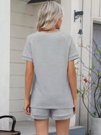 Solid color short sleeve top and shorts two-piece set by Trendsi, casual summer outfit, lightweight fabric, comfortable fit.