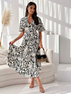 Printed Flutter Sleeve Midi Dress by Plush Fashion Hub, featuring a colorful design and flowy fabric, perfect for stylish occasions.