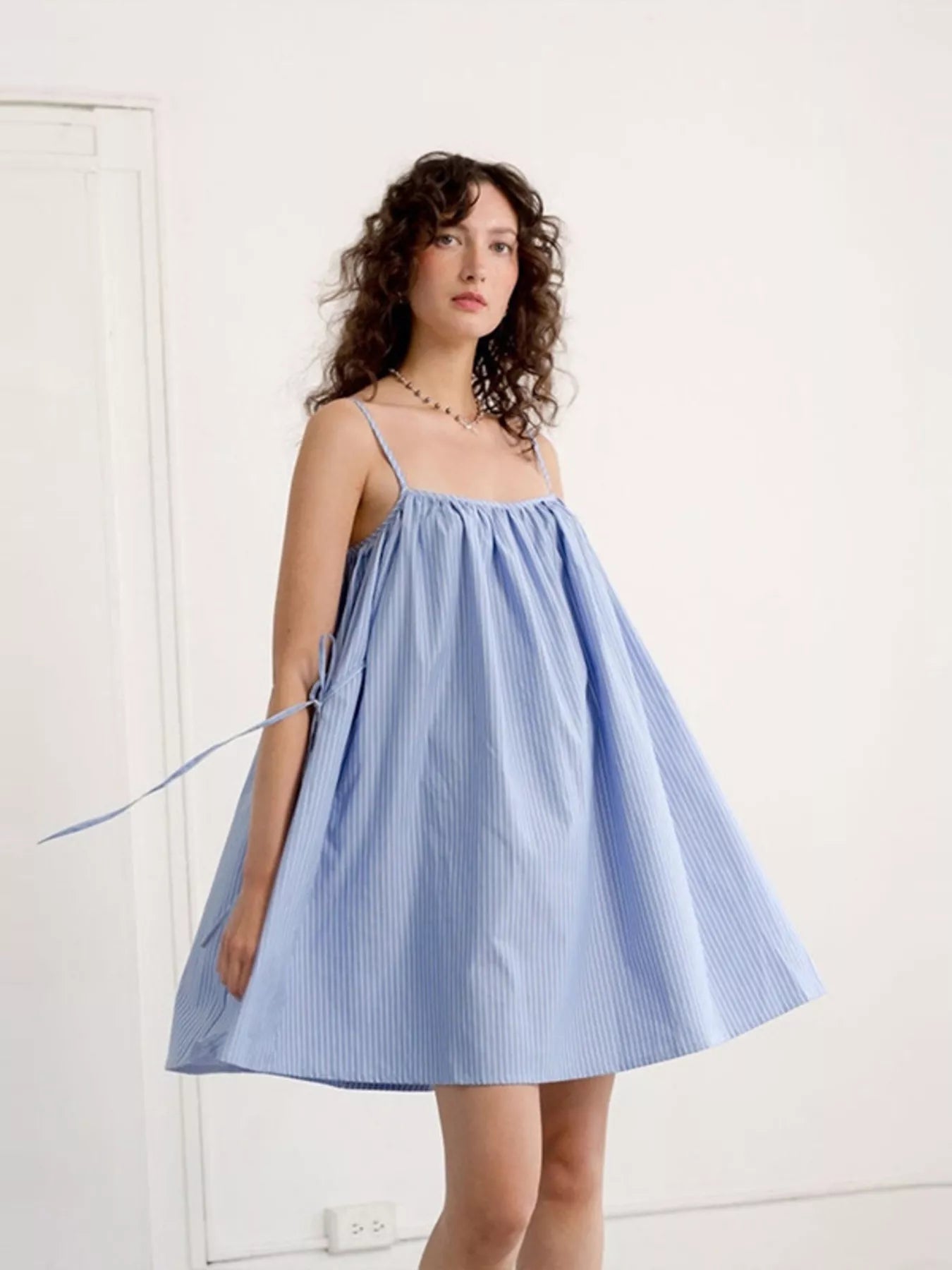 Polka dot spaghetti strap mini dress by Shopimist, featuring a stylish pattern and lightweight fabric on a dress form.