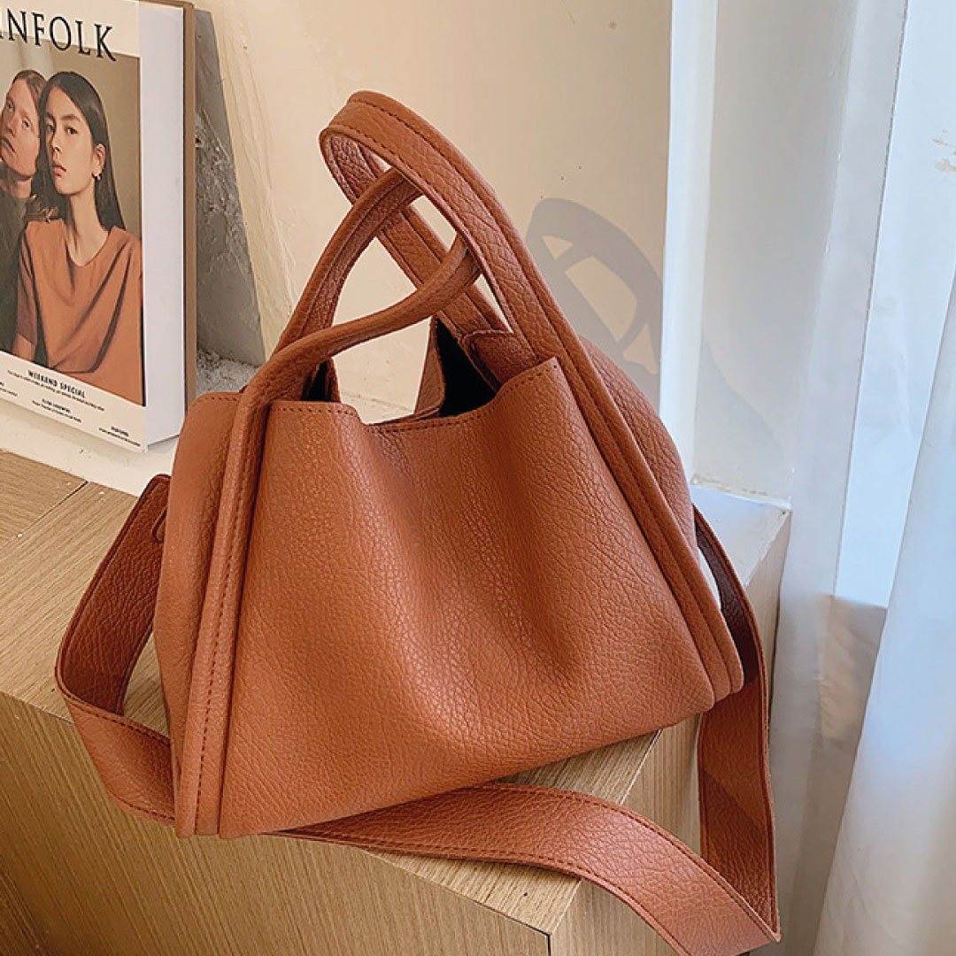 LadyShow.Store Kira Handbag with sleek design, featuring a structured silhouette and stylish handles in a close-up image.