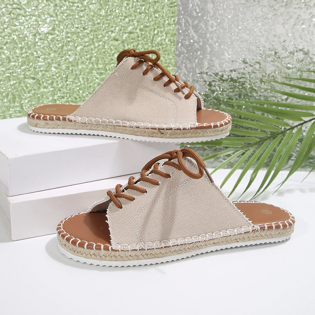 Women's lace-up open toe flat sandals in faux leather, trendy slip-on shoes with stylish design and comfortable fit.