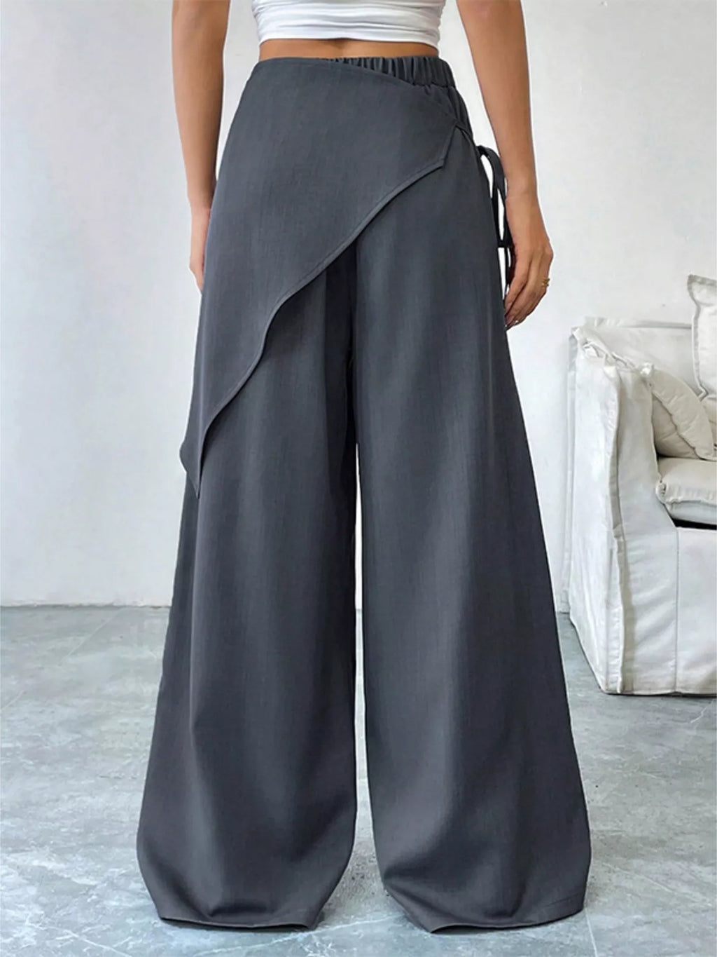 Asymmetrical wrap wide-leg pants by Plush Fashion Hub, featuring a stylish design with flowing fabric and a modern silhouette.