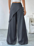 Asymmetrical wrap wide-leg pants by Plush Fashion Hub, featuring a stylish design with flowing fabric and a modern silhouette.