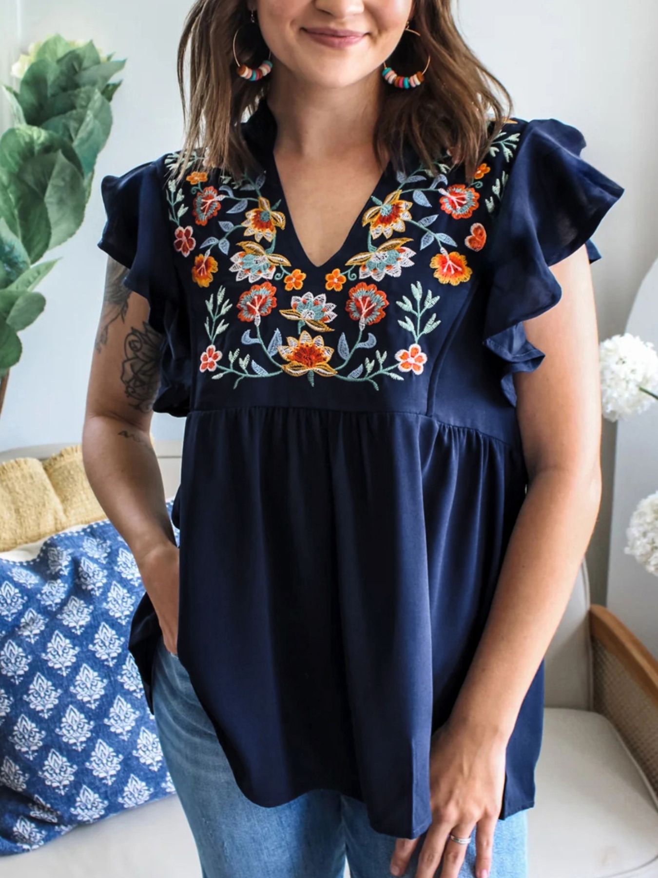 Women's embroidered floral ruffle sleeve blouse by Trendsi, featuring lightweight fabric and elegant floral embroidery.