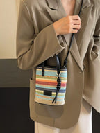 Striped woven mini crossbody bag with adjustable strap from Trendsi, featuring colorful horizontal stripes and a compact design.