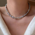 Elegant pearl choker necklace by Shopimist featuring a string of lustrous white pearls on a delicate chain.
