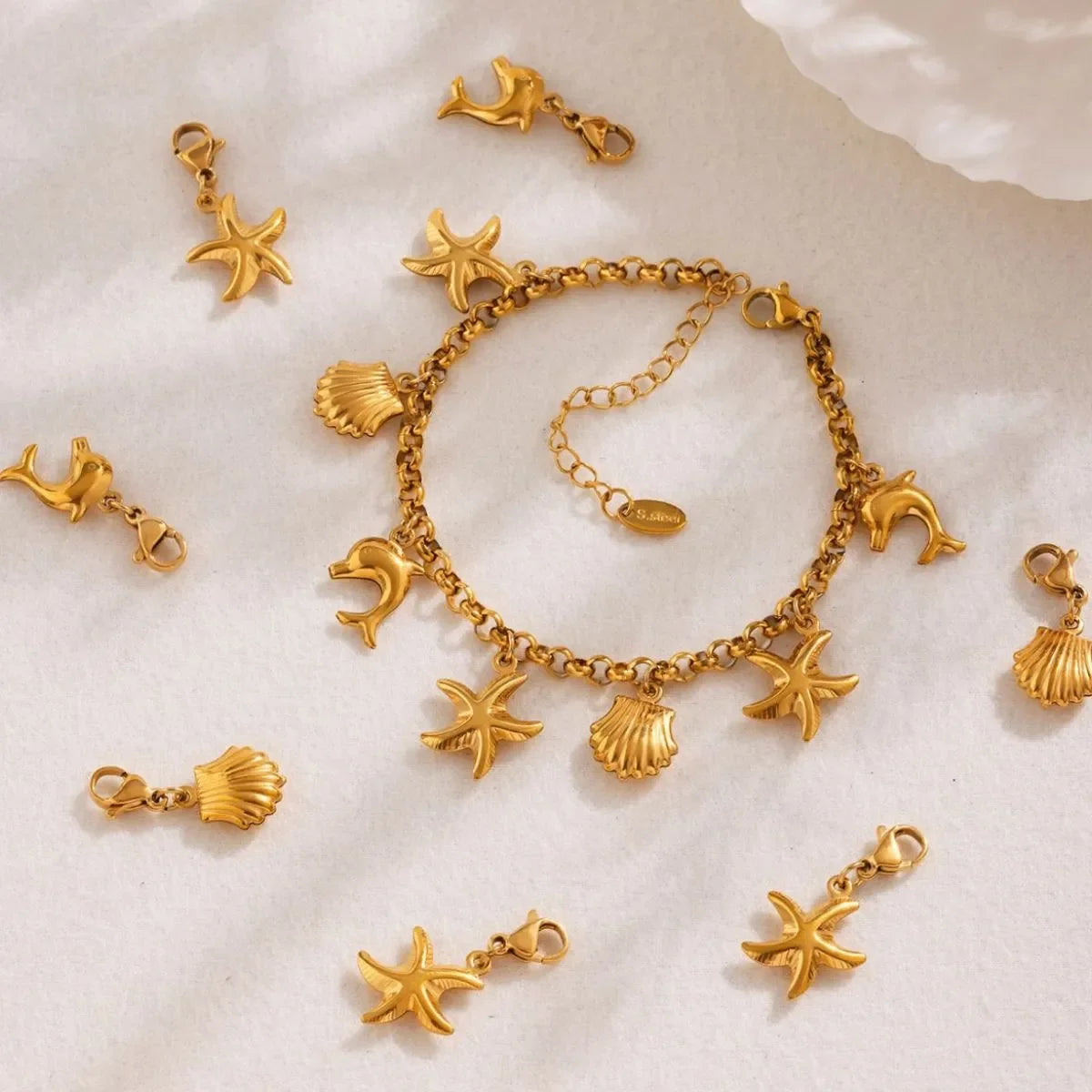 18K gold-plated sea shell charm bracelet with delicate chain and ocean-inspired shell charms, stylish and elegant jewelry accessory.