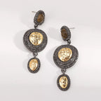 Vintage-inspired dangle earrings with gold accents, featuring intricate design and elegant craftsmanship.