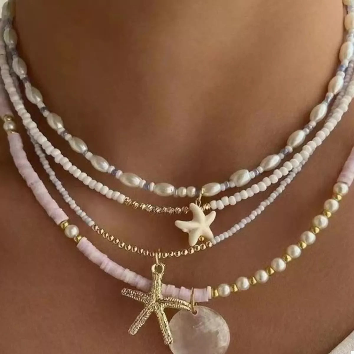 Beaded starfish charm necklace with four starfish pendants on a delicate chain, designed by Plush Fashion Hub.