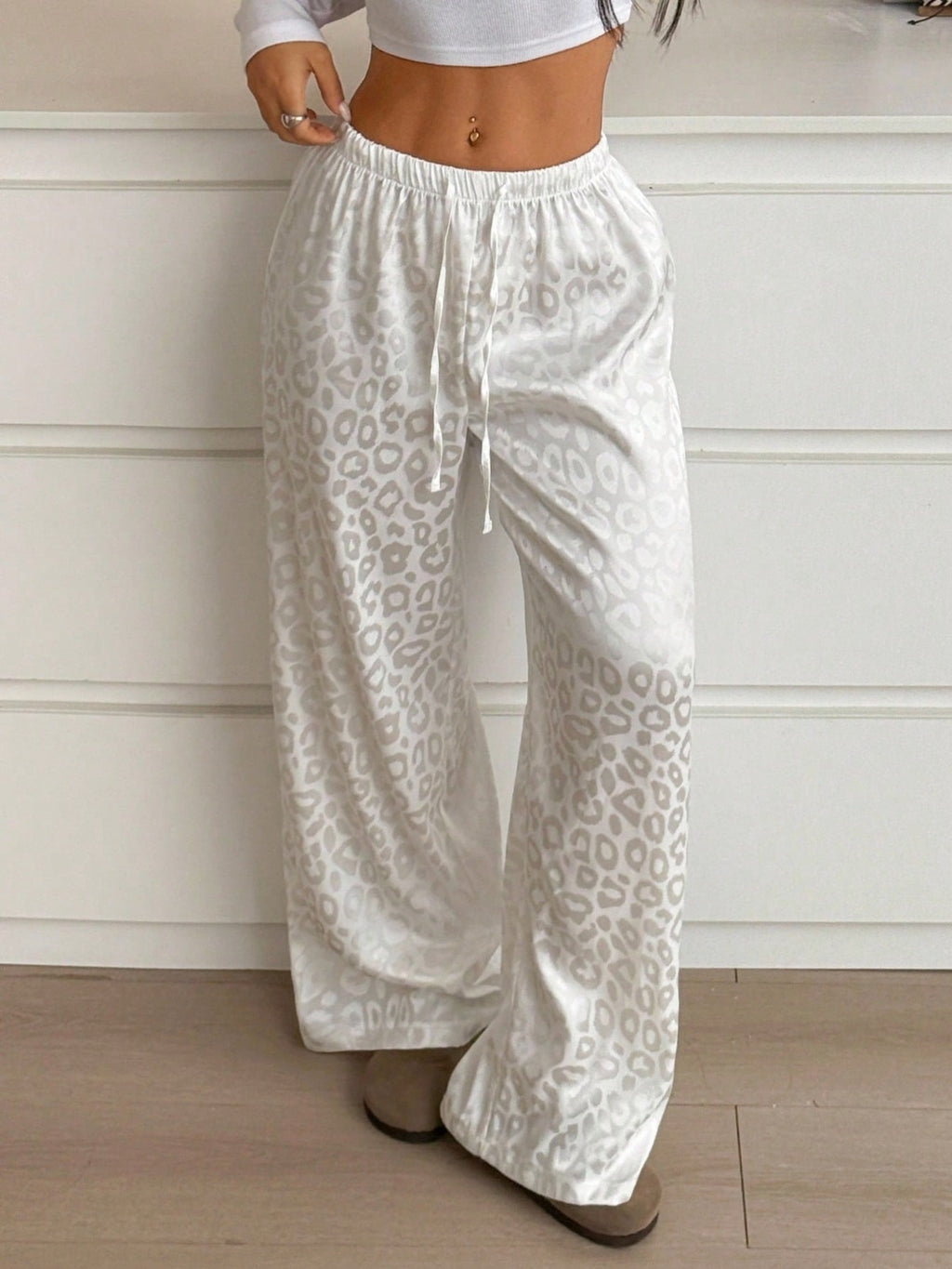 Women's leopard print wide leg trousers with adjustable drawstring waist from Trendsi, featuring a stylish and comfortable fit.