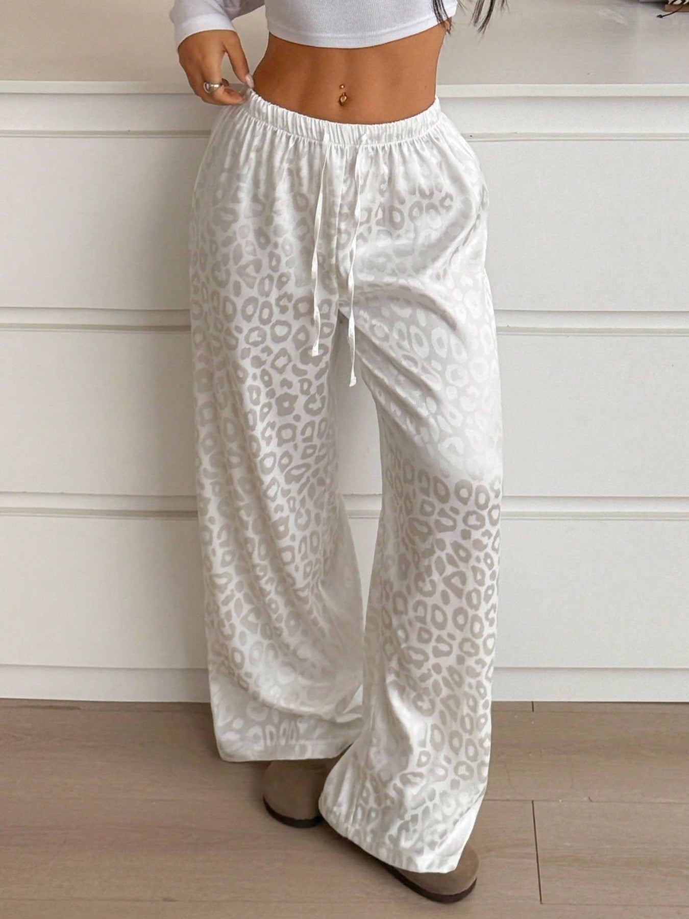 Women's leopard print wide leg trousers with adjustable drawstring waist from Trendsi, featuring a stylish and comfortable fit.