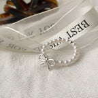 Silver bow-shaped ring with pearl beads from Shopimist, featuring delicate beaded detailing and elegant design.