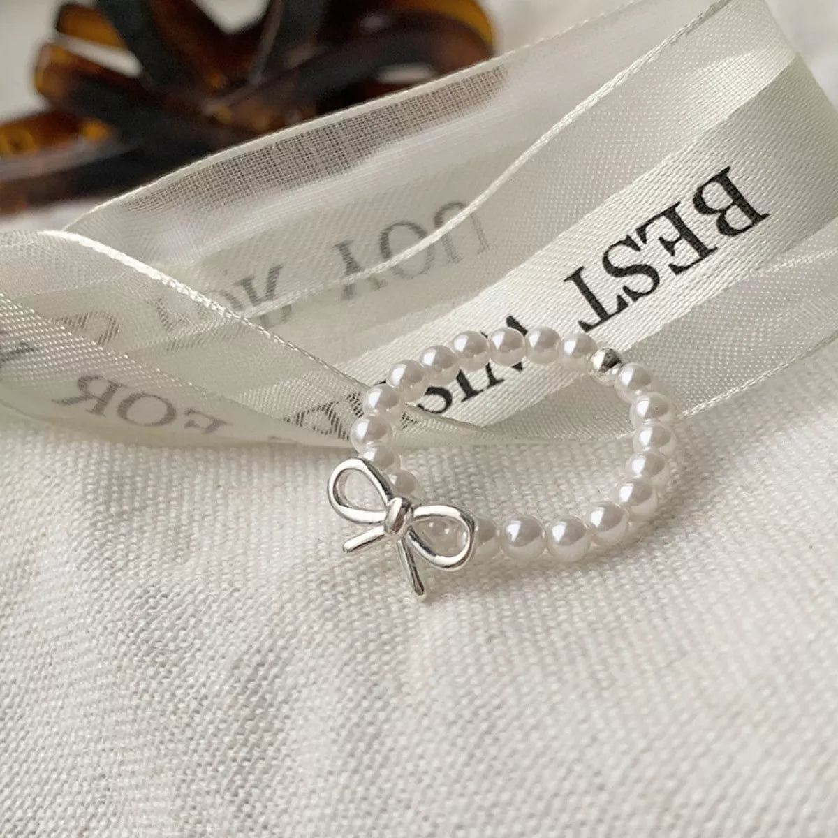 Silver bow-shaped ring with pearl beads from Shopimist, featuring delicate beaded detailing and elegant design.