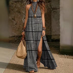 Women's printed halterneck split maxi dress by Plush Fashion Hub, sleeveless and loose fit with vibrant floral pattern.