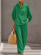 Plus size women's two-piece dress set with button details, featuring a 3/4 sleeve top and matching pants by Trendsi.