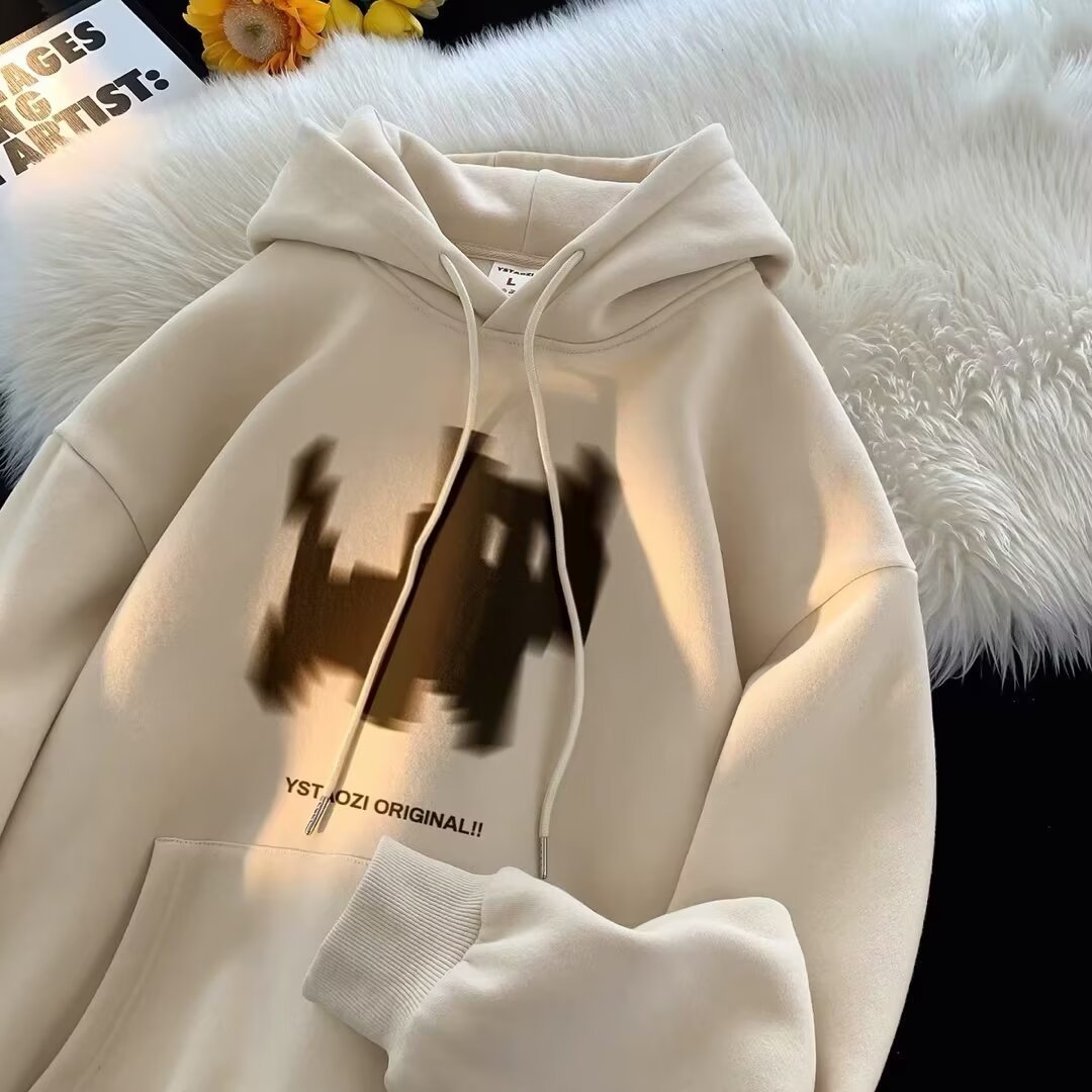 Beige cotton hoodie with a blurry brown graphic, front pocket, drawstrings, and text reading YST TOZI ORIGINAL!!.