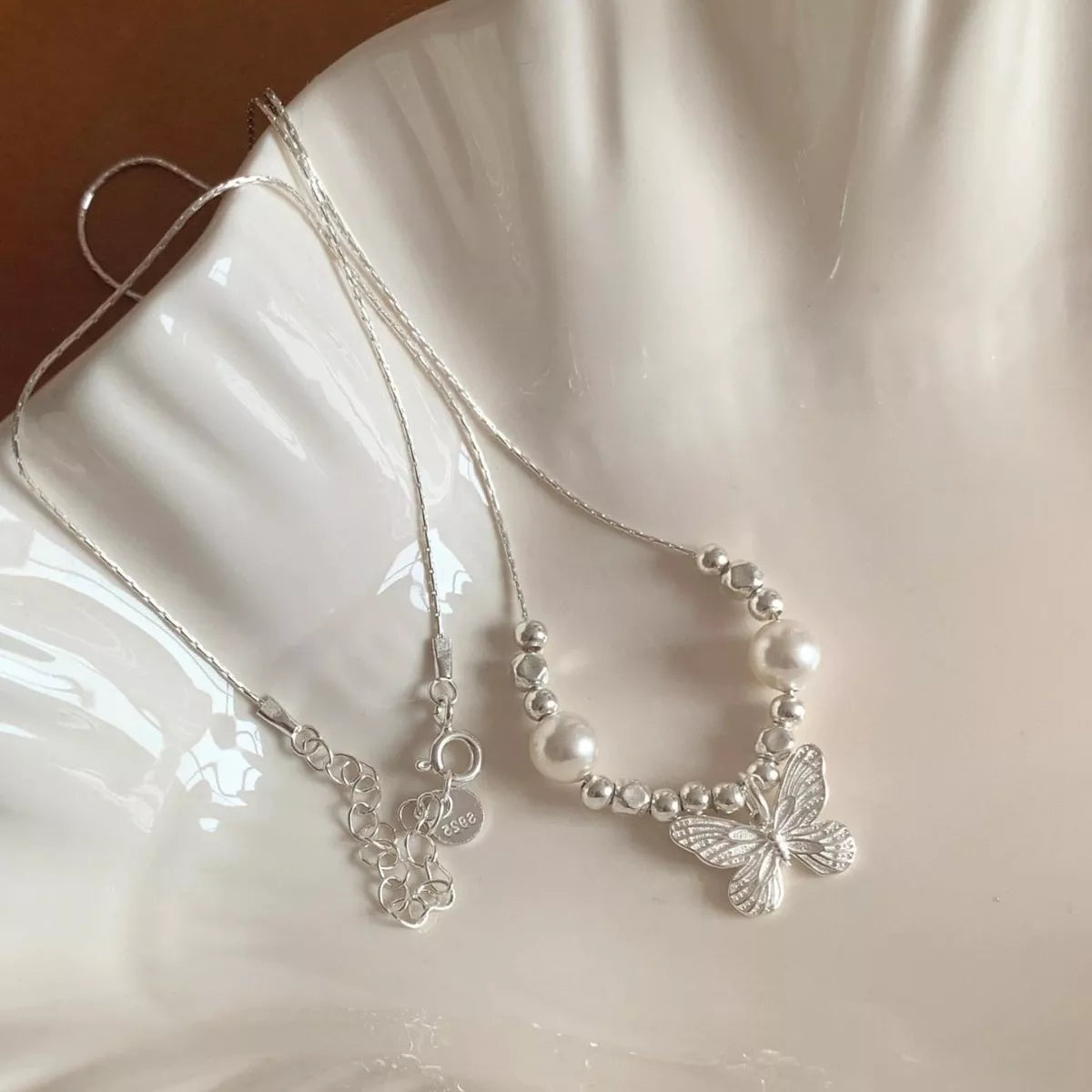 Butterfly pearl pendant necklace featuring a delicate pearl and butterfly charm, stylish jewelry by Plush Fashion Hub