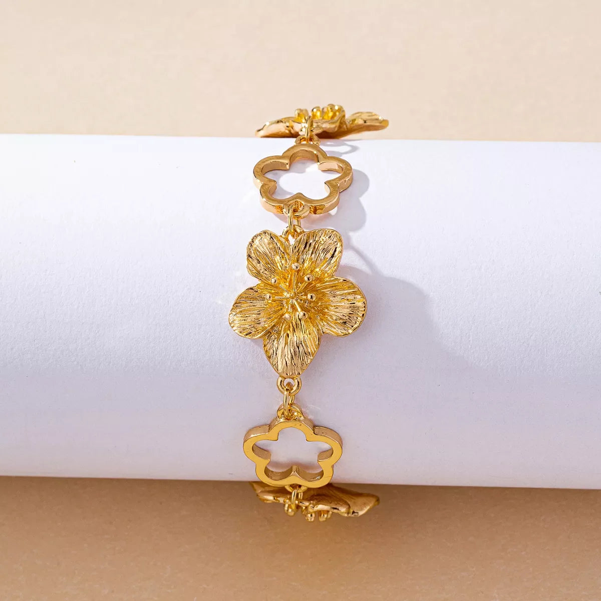 18K gold-plated flower bracelet with delicate floral charms, showcasing elegant jewelry design and craftsmanship.