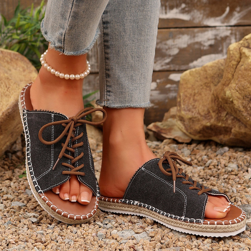 Women's lace-up open toe flat sandals in faux leather with a stylish design, perfect for casual summer wear.