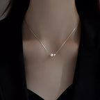 Sterling silver pearl necklace with lustrous white pearls and delicate chain, designed for elegant wear.
